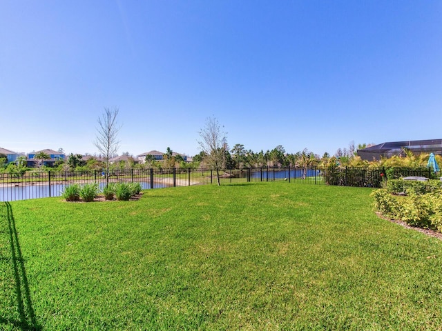 view of yard featuring a water view and fence