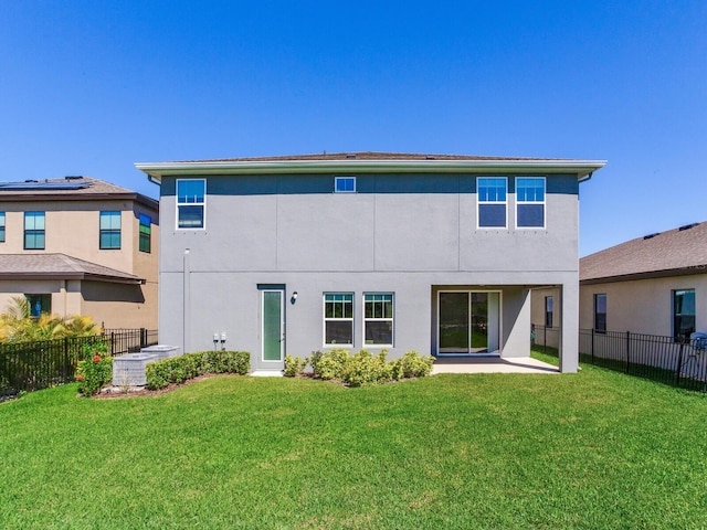 back of property with stucco siding, a fenced backyard, a patio area, and a yard