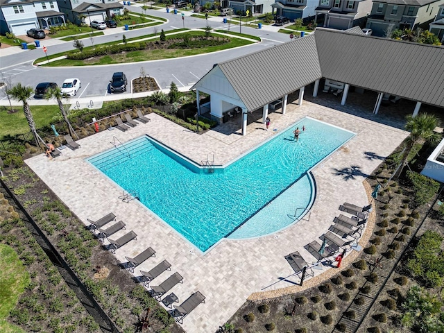 pool with a residential view and a patio
