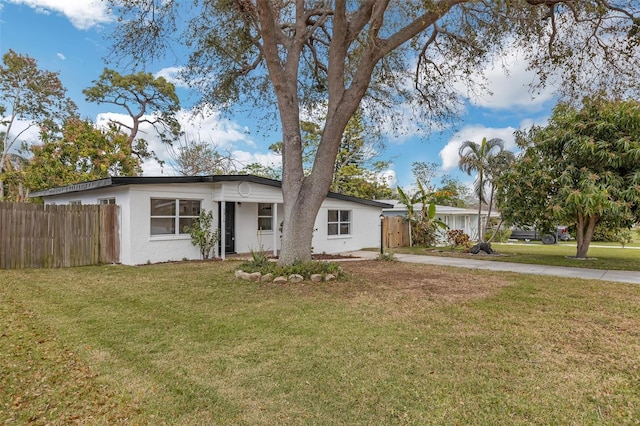 ranch-style home featuring concrete driveway, a front yard, fence, and stucco siding