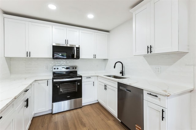 kitchen with light wood-style flooring, white cabinetry, stainless steel appliances, and a sink