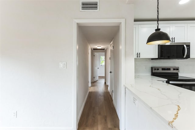 kitchen featuring stainless steel appliances, visible vents, decorative backsplash, white cabinets, and wood finished floors