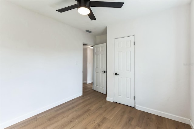 unfurnished bedroom with light wood finished floors, a closet, visible vents, a ceiling fan, and baseboards