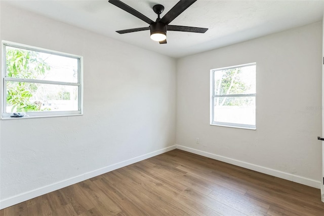 empty room with ceiling fan, baseboards, and wood finished floors