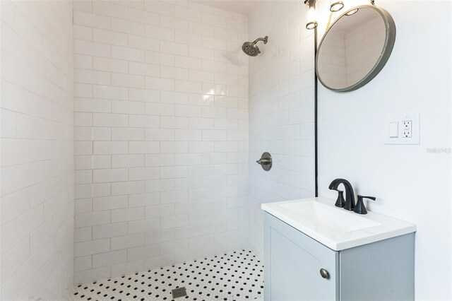 full bath with a tile shower and vanity