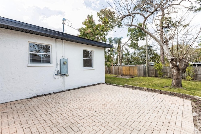 exterior space with a patio area, a lawn, a fenced backyard, and stucco siding