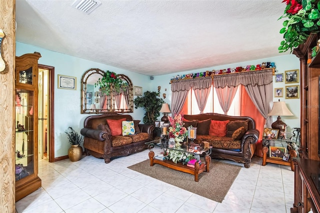 living area with visible vents, a textured ceiling, and light tile patterned flooring