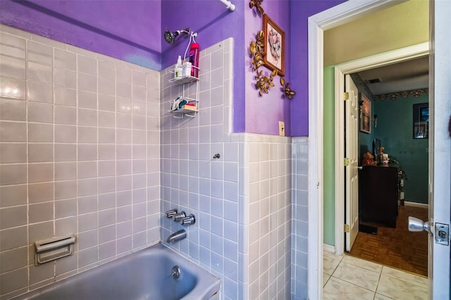 full bathroom with washtub / shower combination, visible vents, tile walls, and tile patterned floors