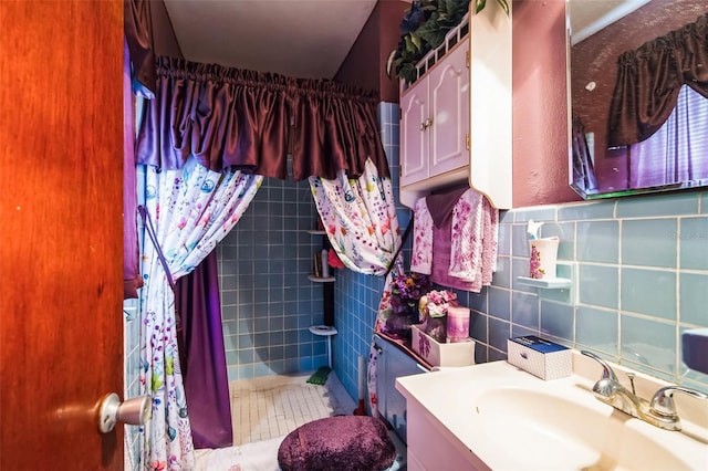 full bath with curtained shower, tile walls, vanity, and tile patterned floors