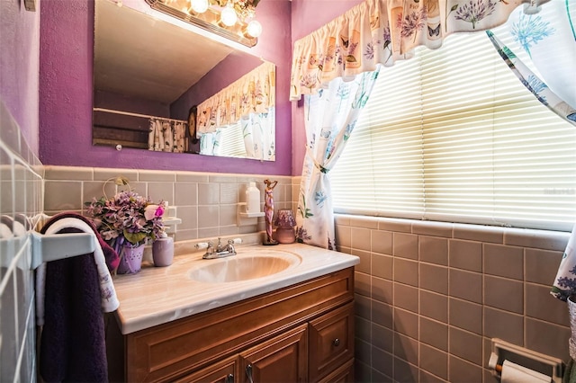 bathroom with wainscoting, vanity, and tile walls