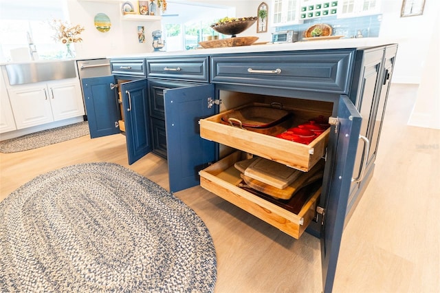 laundry room with a sink and light wood-type flooring