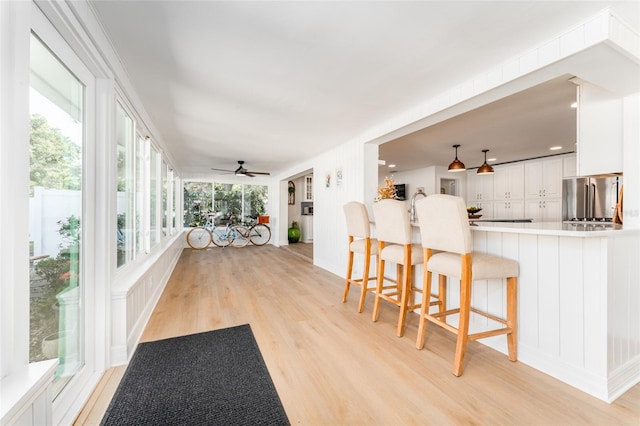 sunroom featuring a sink and ceiling fan