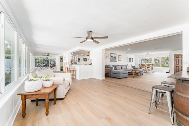 living room with light wood-style flooring and a ceiling fan