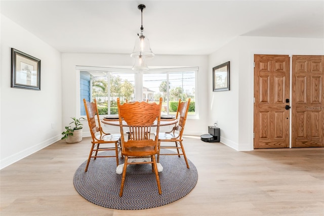 dining area featuring baseboards and light wood-style flooring