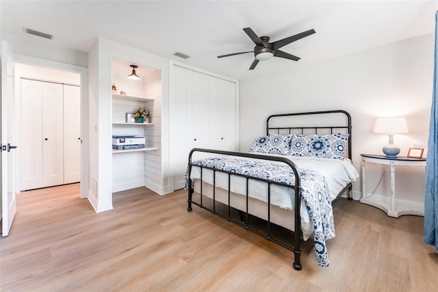 bedroom with visible vents, baseboards, wood finished floors, and a ceiling fan