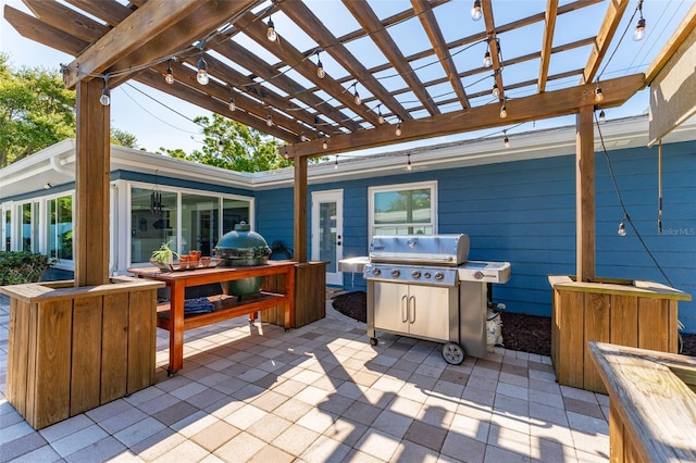 view of patio with area for grilling and a pergola