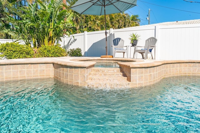 view of swimming pool with a fenced backyard and a hot tub