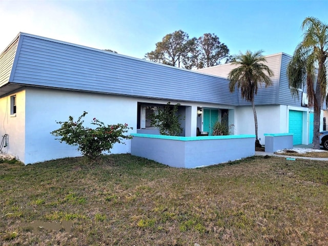 view of front of house with a front lawn and stucco siding