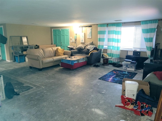 living area featuring visible vents and unfinished concrete flooring