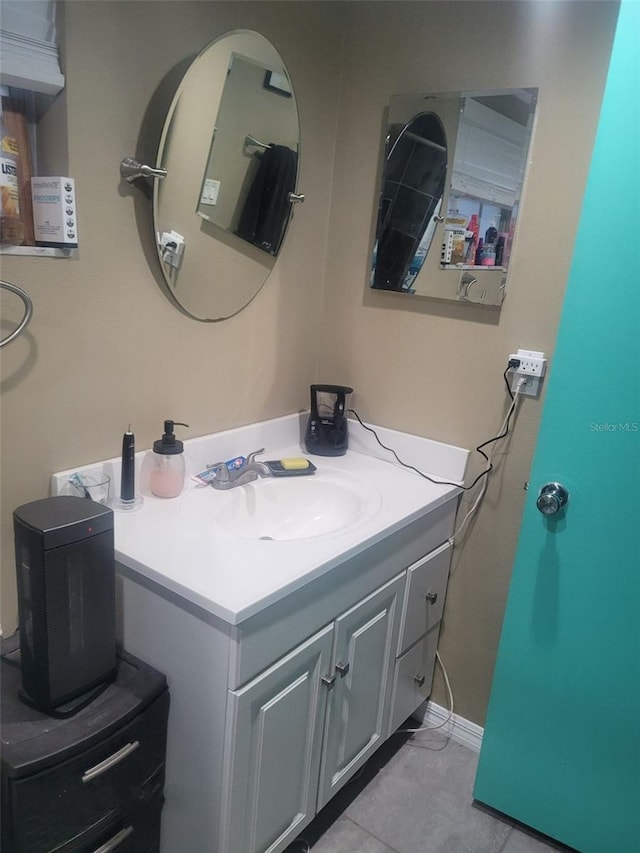 bathroom with vanity, baseboards, and tile patterned floors