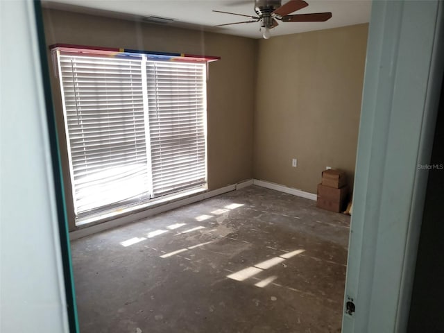 unfurnished room with baseboards, visible vents, and a ceiling fan