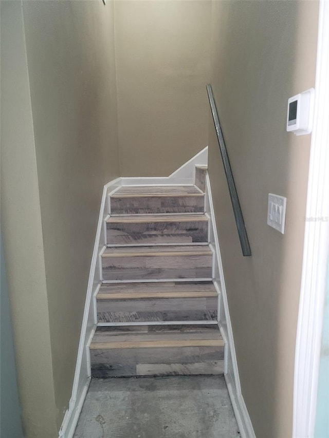 stairs featuring unfinished concrete floors