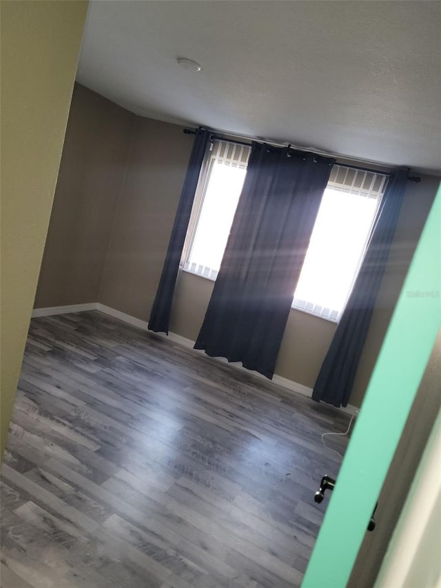 empty room with wood finished floors and baseboards