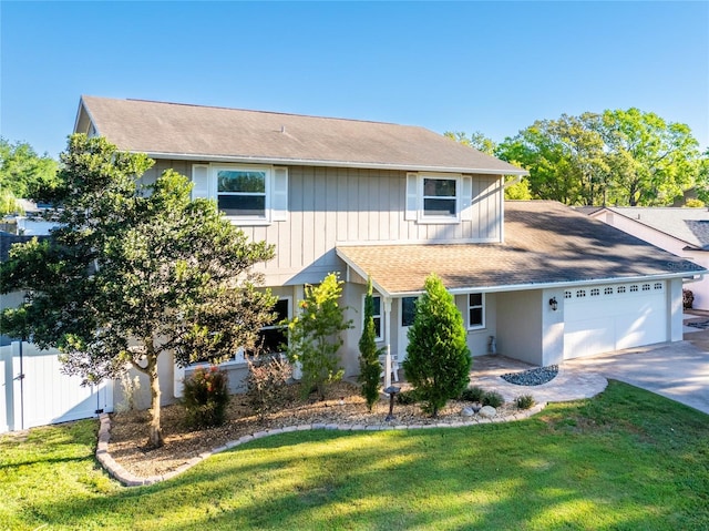 traditional home featuring fence, a shingled roof, a front lawn, concrete driveway, and a garage