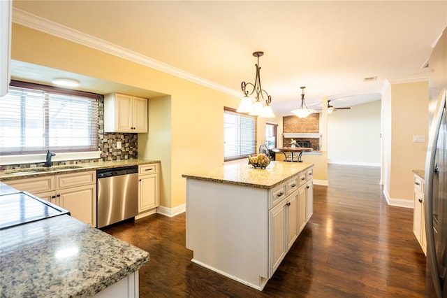 kitchen with a kitchen island, crown molding, appliances with stainless steel finishes, a fireplace, and a sink