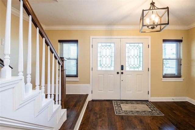 entryway featuring a notable chandelier, dark wood-style flooring, stairs, and ornamental molding