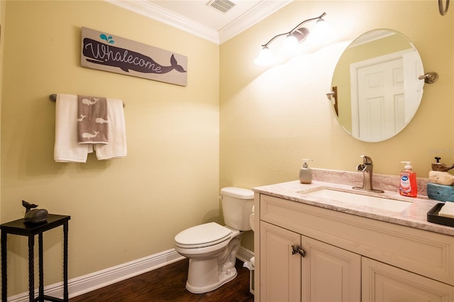 half bathroom with visible vents, toilet, ornamental molding, wood finished floors, and vanity