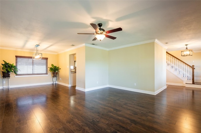 spare room featuring crown molding, baseboards, dark wood finished floors, stairs, and ceiling fan with notable chandelier