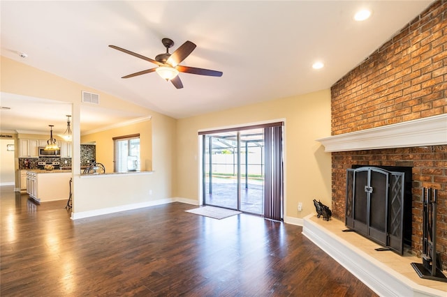 unfurnished living room featuring visible vents, dark wood-type flooring, baseboards, a fireplace, and a ceiling fan