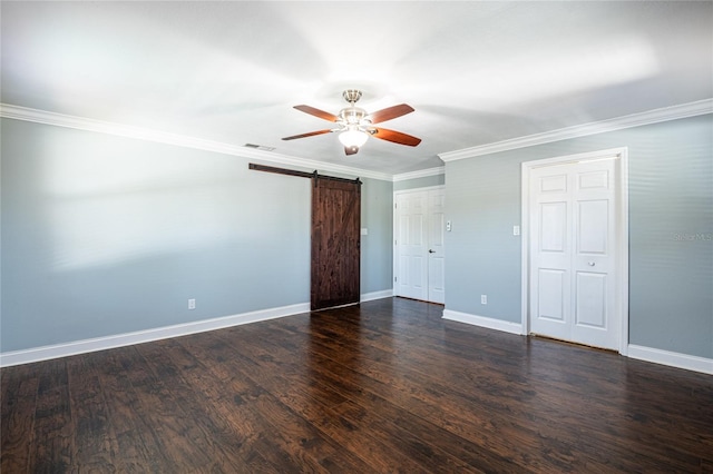 unfurnished bedroom with wood finished floors, visible vents, baseboards, crown molding, and a barn door