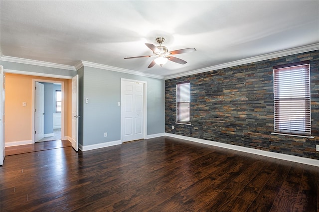 spare room with baseboards, wood finished floors, a ceiling fan, and ornamental molding