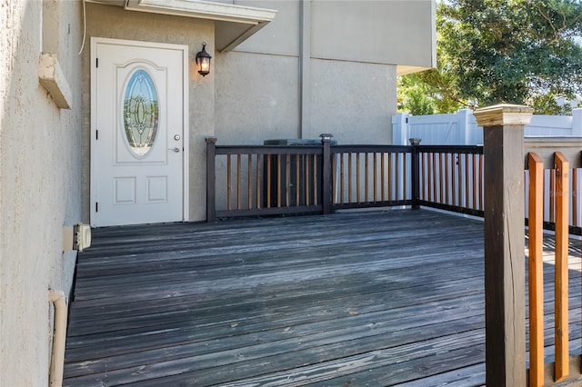 doorway to property featuring stucco siding and a wooden deck