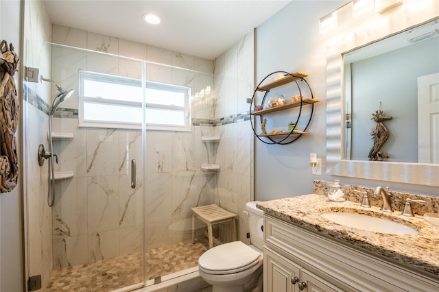 bathroom featuring a marble finish shower, toilet, and vanity