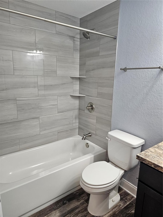 bathroom with a textured wall, wood finished floors, toilet, and baseboards