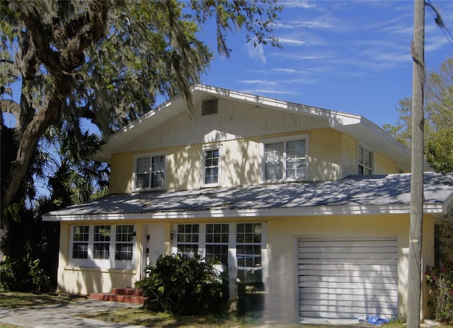 view of front of home featuring a garage, roof with shingles, and stucco siding