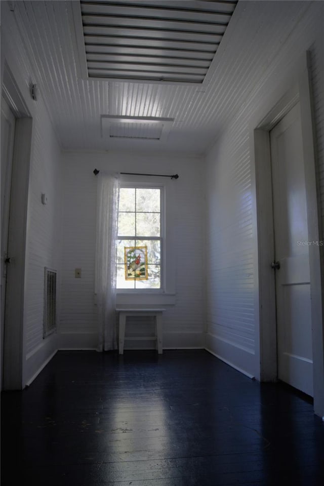 spare room with visible vents, baseboards, and wood finished floors