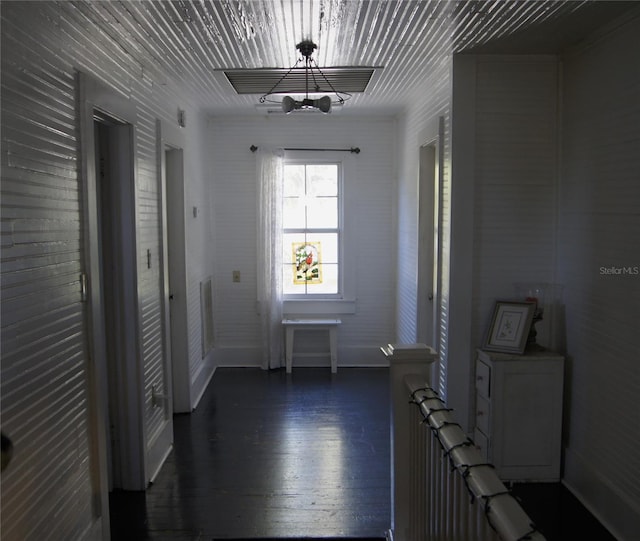 corridor with wood finished floors and baseboards