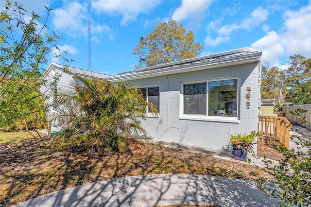 view of property exterior with fence and concrete block siding