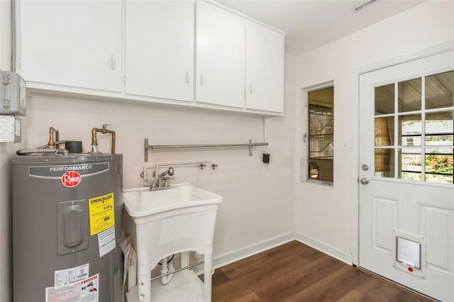 interior space with visible vents, dark wood-type flooring, electric water heater, and baseboards