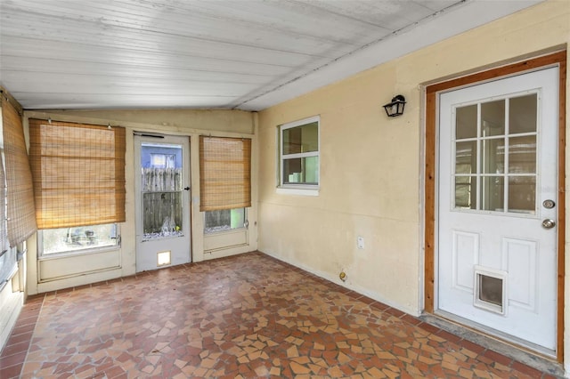 unfurnished sunroom featuring lofted ceiling