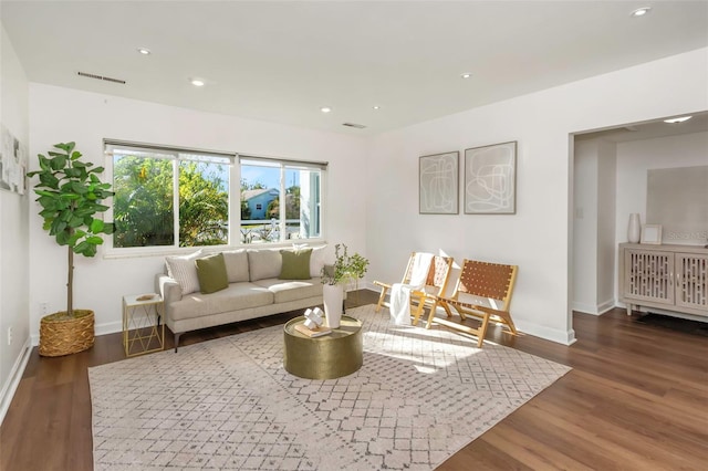 living area with baseboards, visible vents, wood finished floors, and recessed lighting