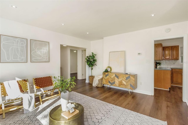 living area with baseboards, dark wood-style flooring, and recessed lighting