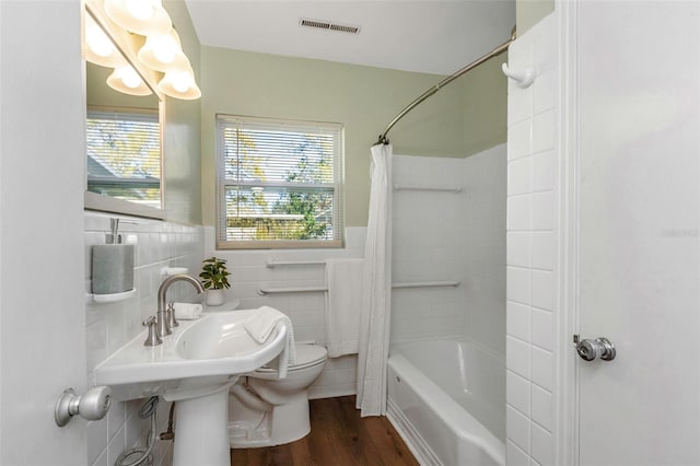 full bath featuring a healthy amount of sunlight, a wainscoted wall, visible vents, and toilet