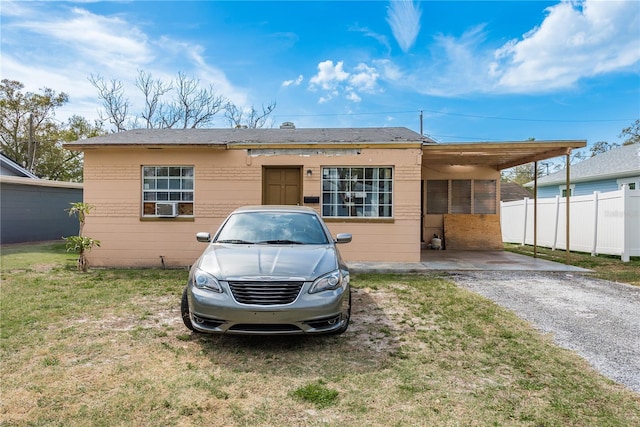 view of front facade with fence, a front lawn, and a carport