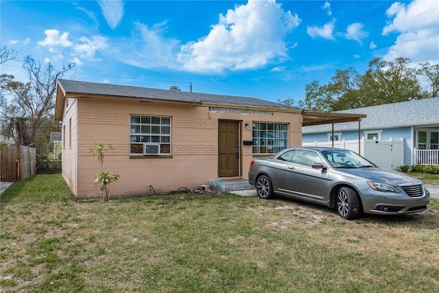 view of front of property featuring fence, a front lawn, and a carport