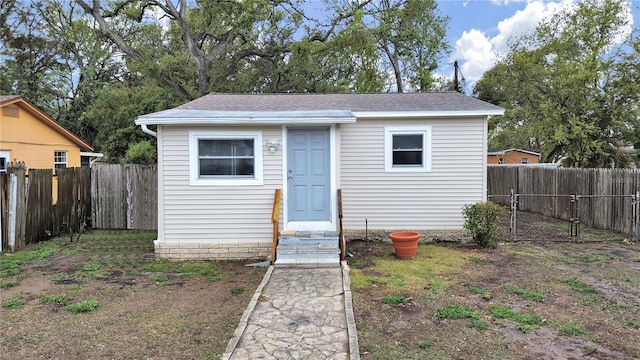 view of outbuilding with entry steps, a fenced backyard, and an outbuilding